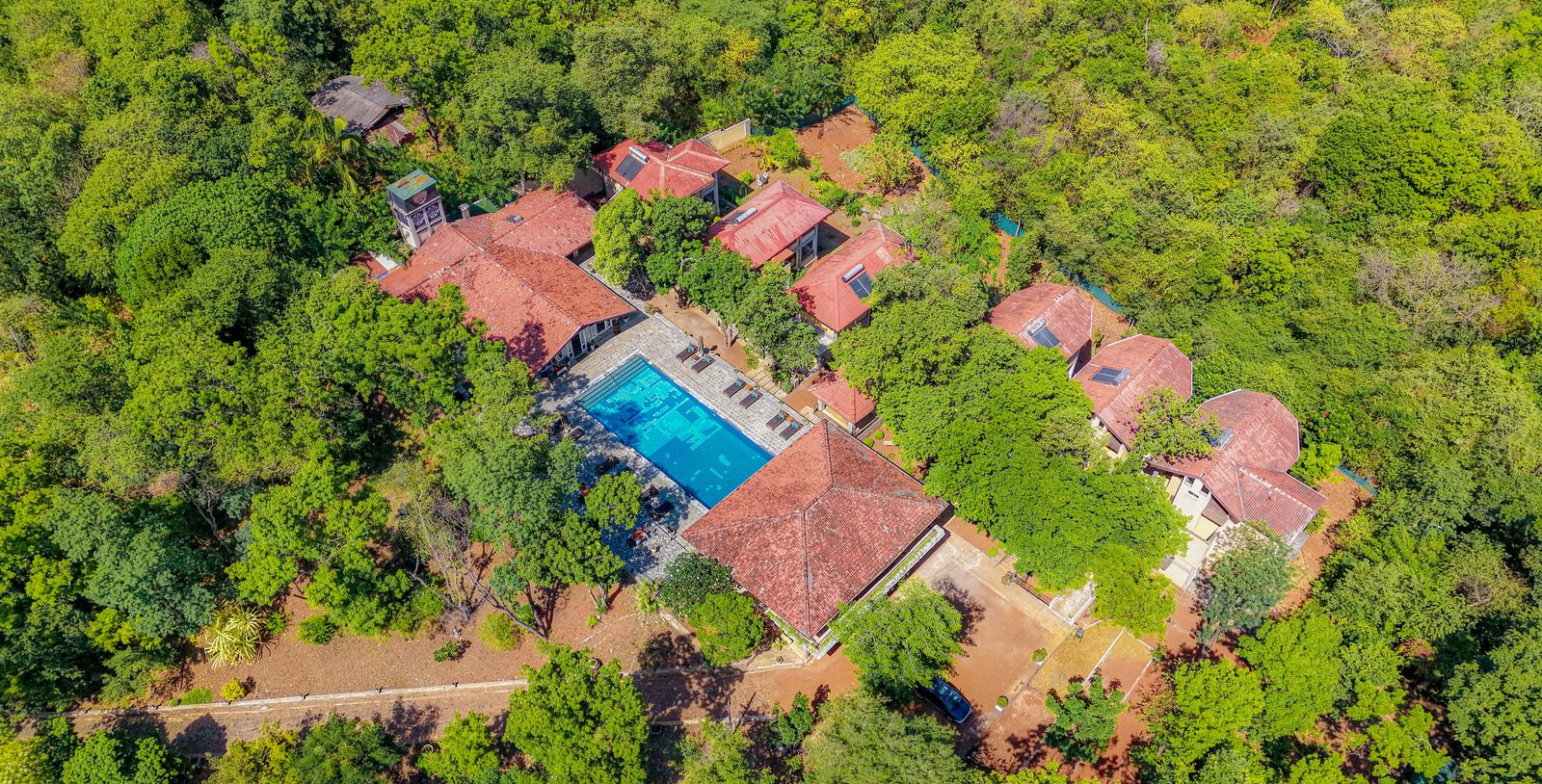 Lake Lodge from above: terracotta roofs and the pool hidden in the forest canopy
